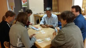 Bild: eine Spielerrunde um den Tisch sitzend