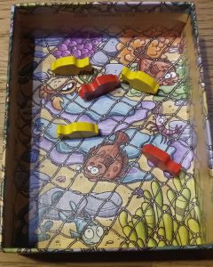 Bild: geöffnete Spielschachtel mit Fischernetz und Holzfischen