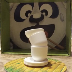 Bild: im Hintergrund Panda-Gesicht in der Schachtel-Innenseite und gestapelte Tellerchen davor