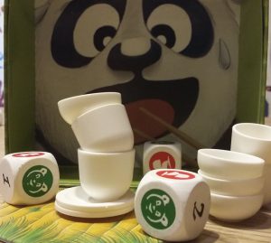 Bild: Würfel mit Pandsymbolen und gestapelte weiße Teller