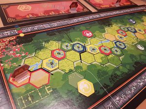 Bild: Spielfeld mit Kärtchen und sonstigem Spielmaterial