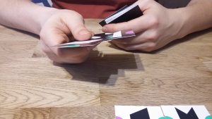 Bild: ein Spieler hält Spielkärtchen in seinen Händen