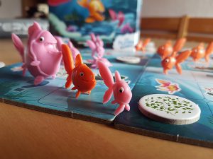 Bild: Spielfeld-Ausschnitt mit Spielfiguren Fische und Spielplättchen
