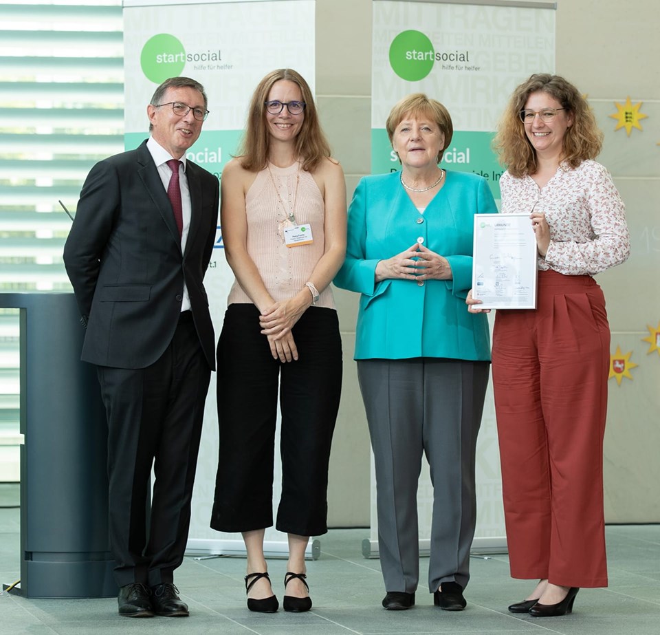 Überreichung der Urkunde durch die damalige Bundeskanzlerin Angela Merkel an das Spielecafé.