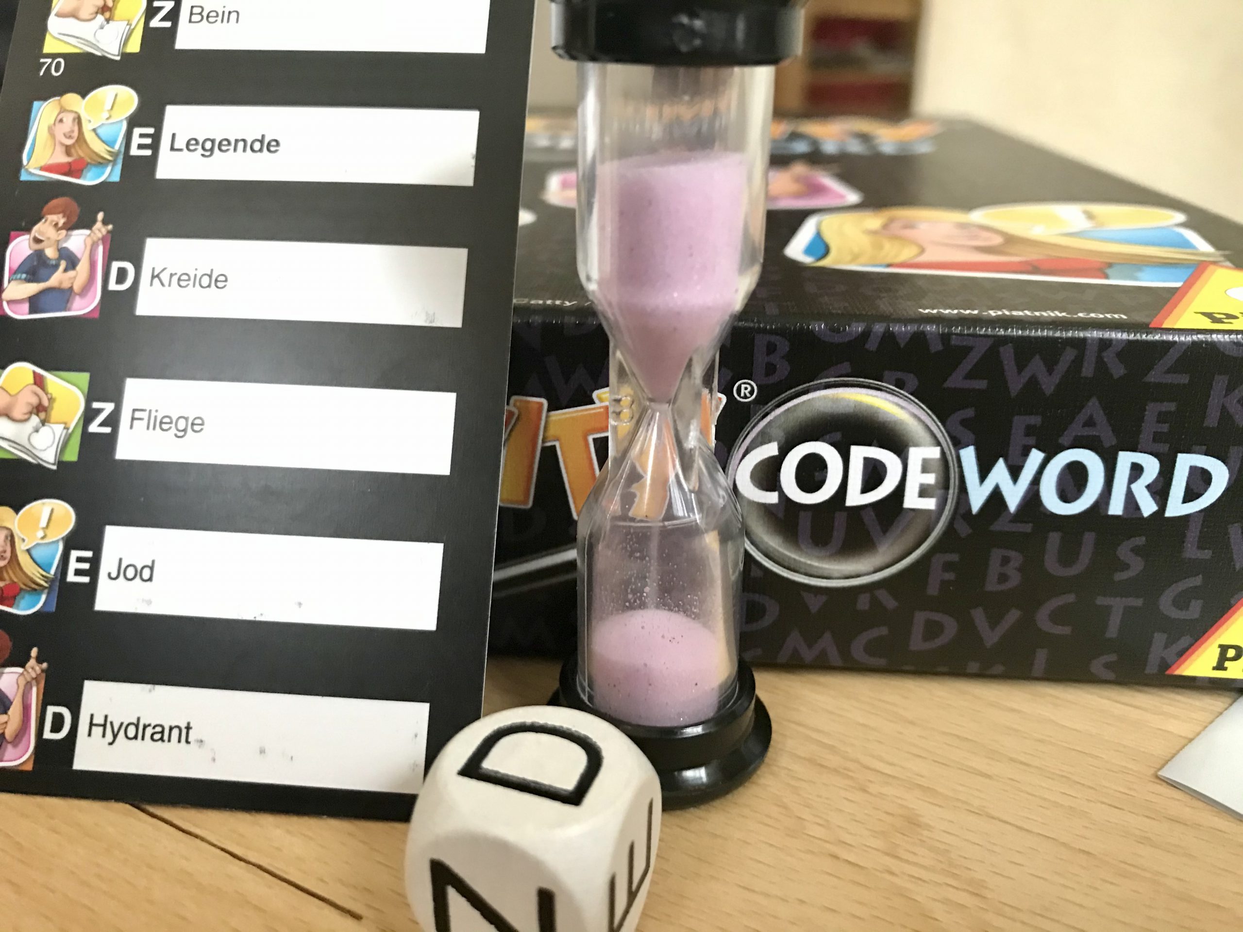 Eine Karte mit sechs Begriffen, daneben Sanduhr und Würfel. 