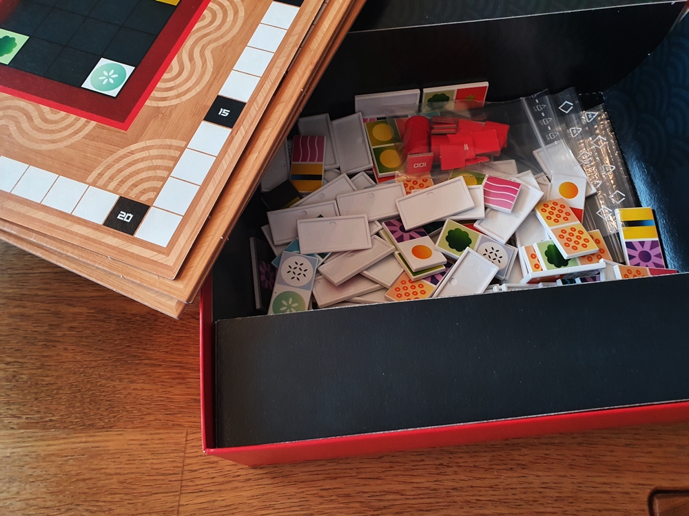 Geöffnete Spieleschachtel, zu knapp einem Viertel gefüllt