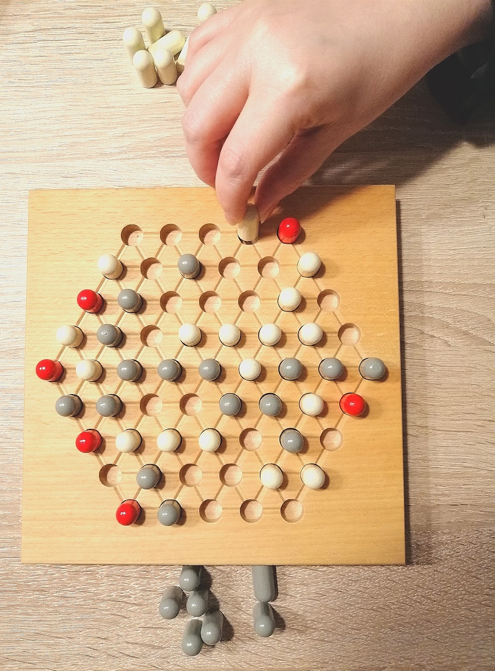 Ein Spielstein wird gesteckt.