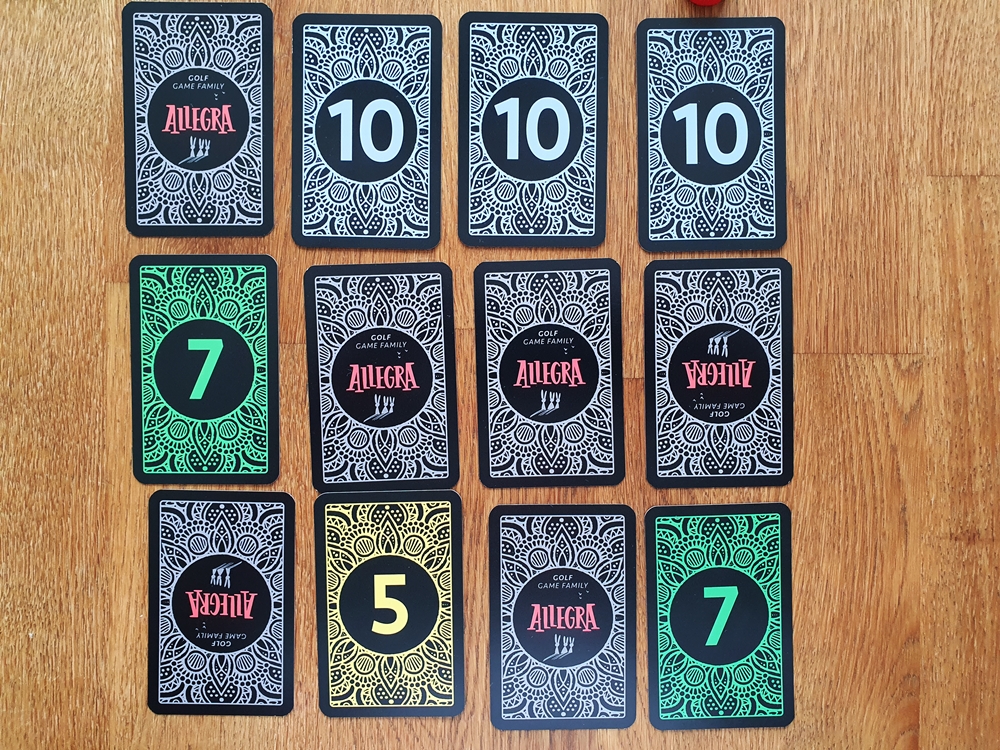 Kartenauslage eines Spielers, einer Spielerin teilweise offen. Oben drei Karten mit dem Wert 10 nebeneinander