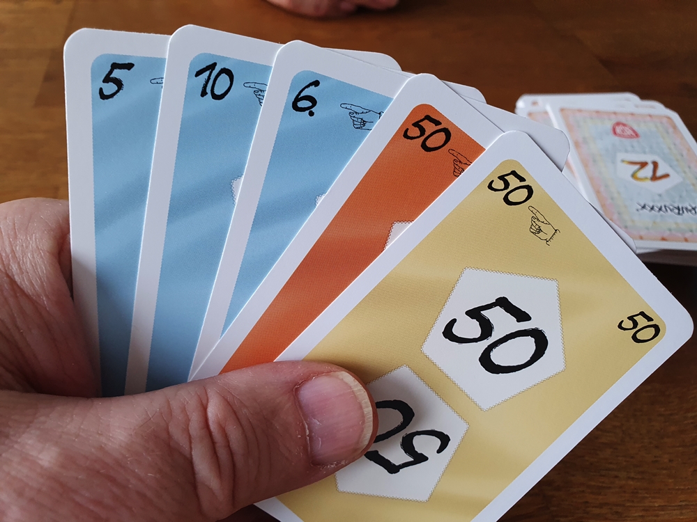 Kartenhand mit zwei Karten im Wert 50 in unterschiedlichen Farben