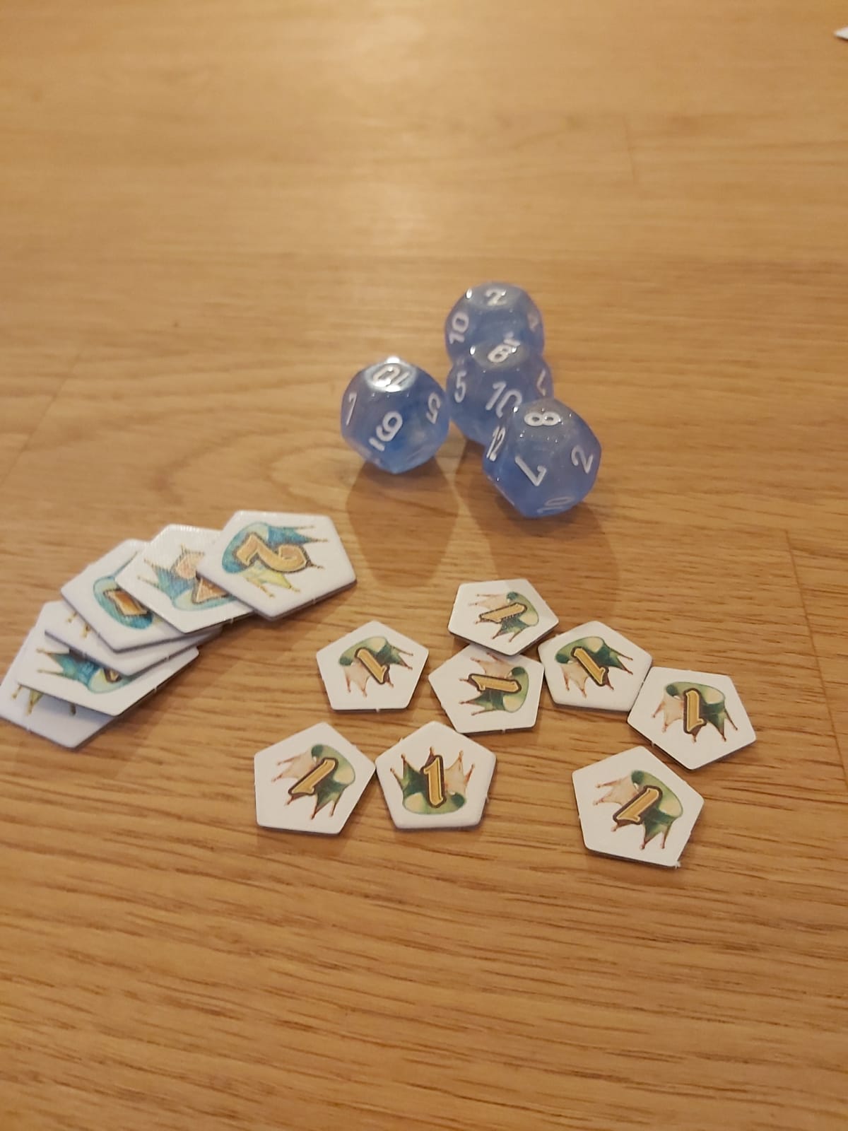 Zu sehen sind die Würfel und Siegpunktmarker des Spiels