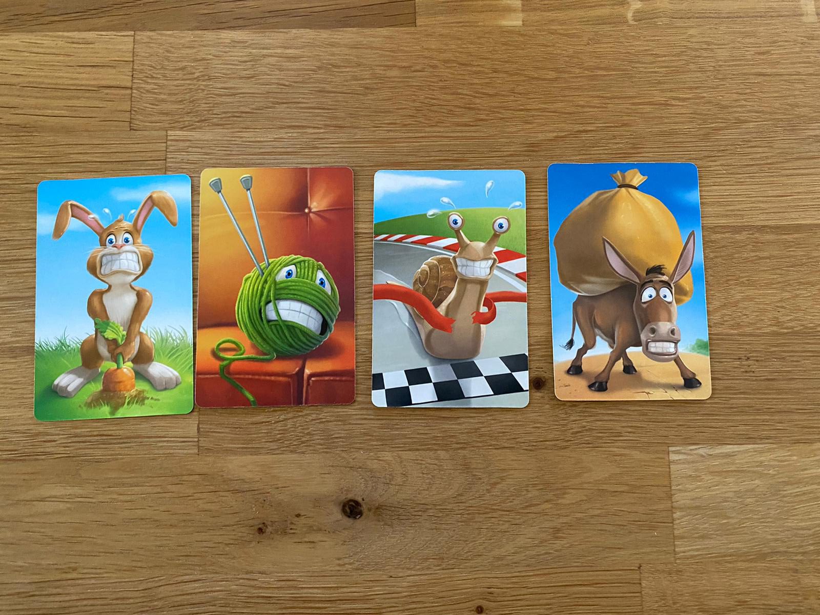 Zu sehen sind 4 der Spielkarten, auf denen unter anderem Tiere eine Emotion abbilden
