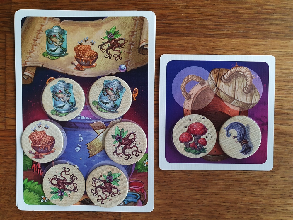 Erfüllte Zaubertrankarte mit Zutatenplättchen belegt, die Müllkarte ist teils belegt