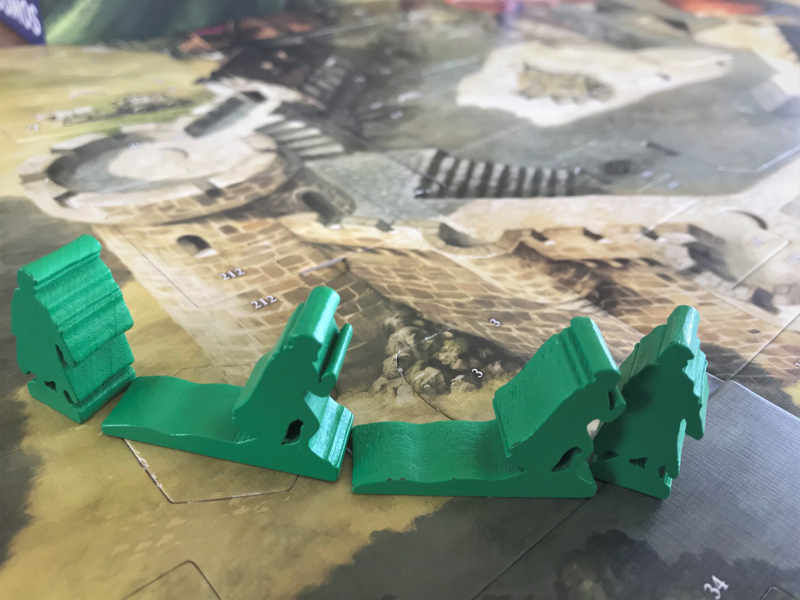 Mit Holzfiguren bewegen sich die Held:innen über den Spielplan