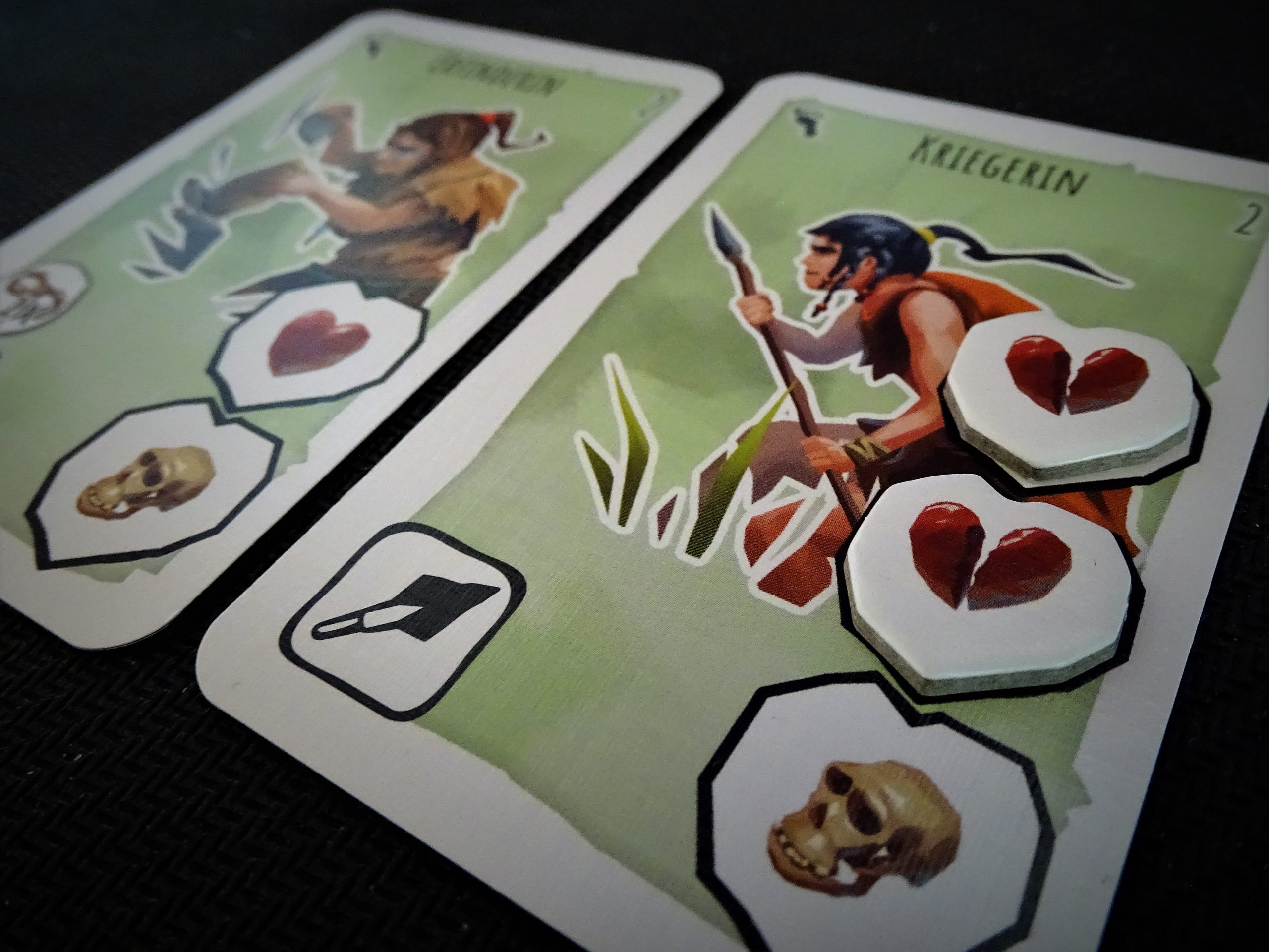 Auf der Karte der Kriegerin liegen schon zwei Herzen. Verliert sie noch ein Leben, kassiert das Team einen Totenkopf. 