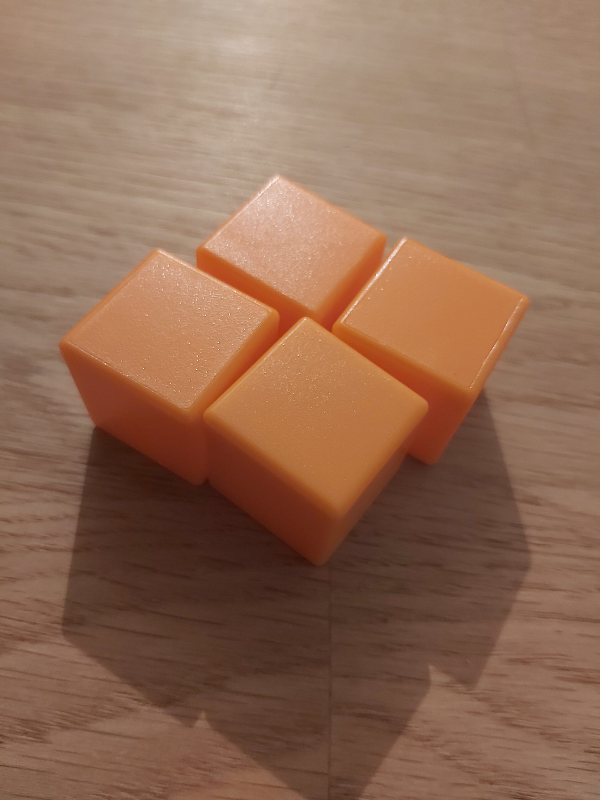 Zu sehen sind 4 orangene Cubies von Rubik's Cage.