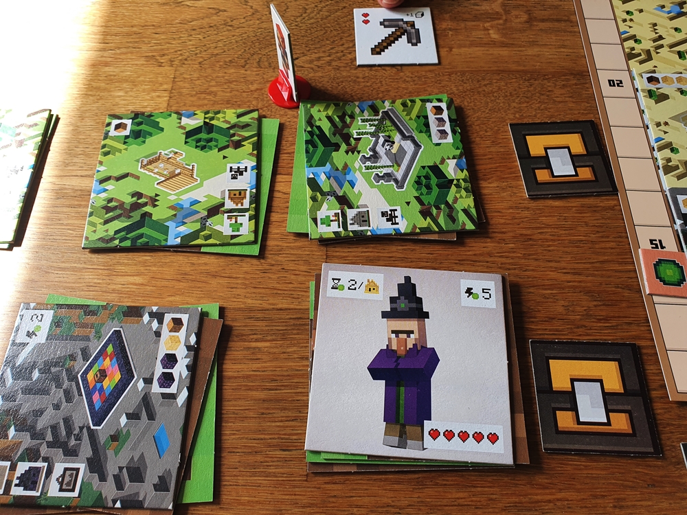 Spielsituation: aufgedeckte Karten mit Landschaften und Monstern, Spielfigur auf Kreuzungspunkt