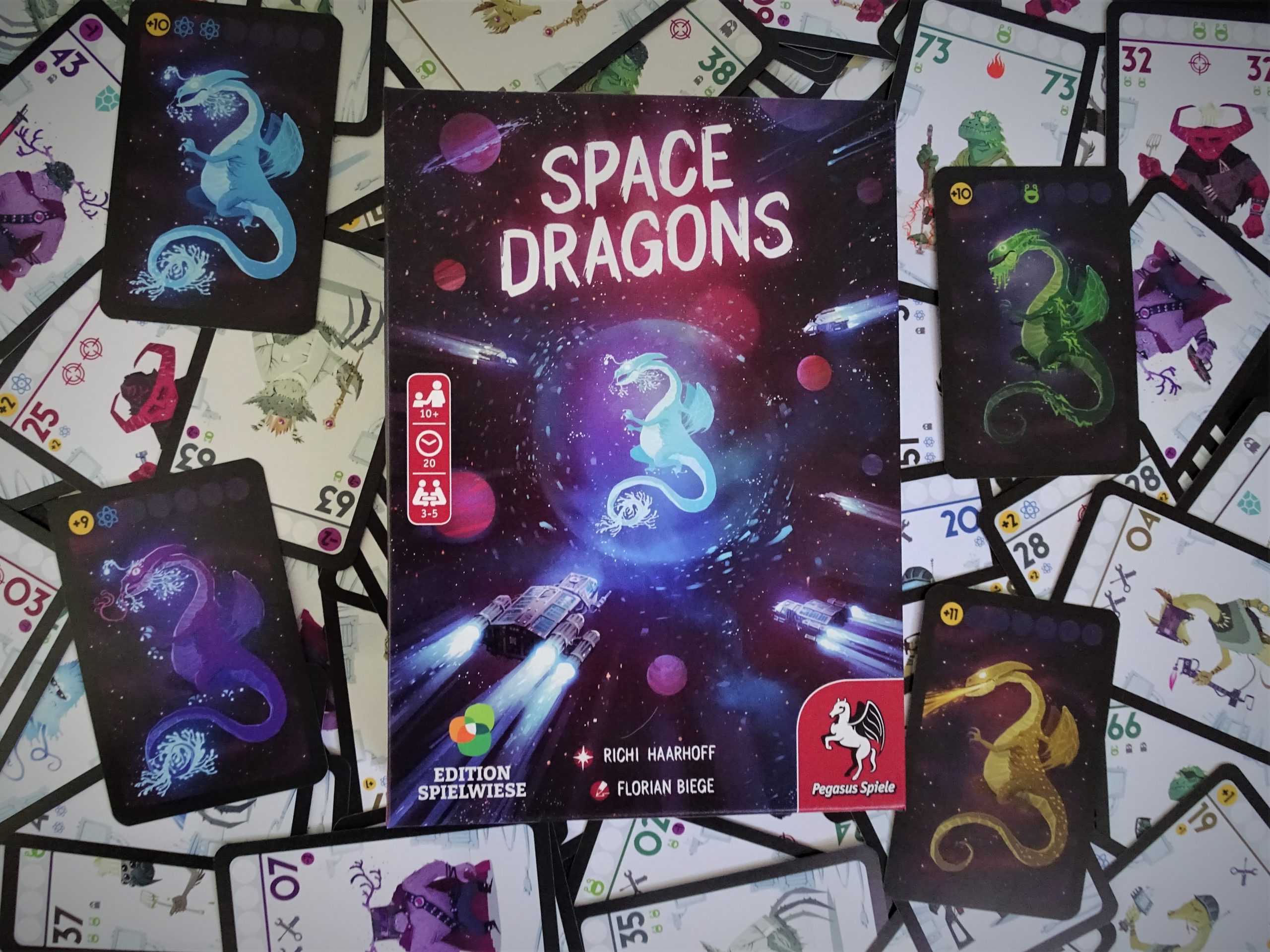 Die Schachtel liegt af den ausgebreiteten Karten. Vier Drachen sind zu sehen.