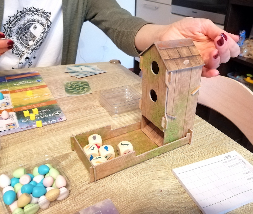 Die Würfel werden zum würfeln in das Vogelhaus geworfen. Eins der schönsten Elemente in diesem Spiel. 