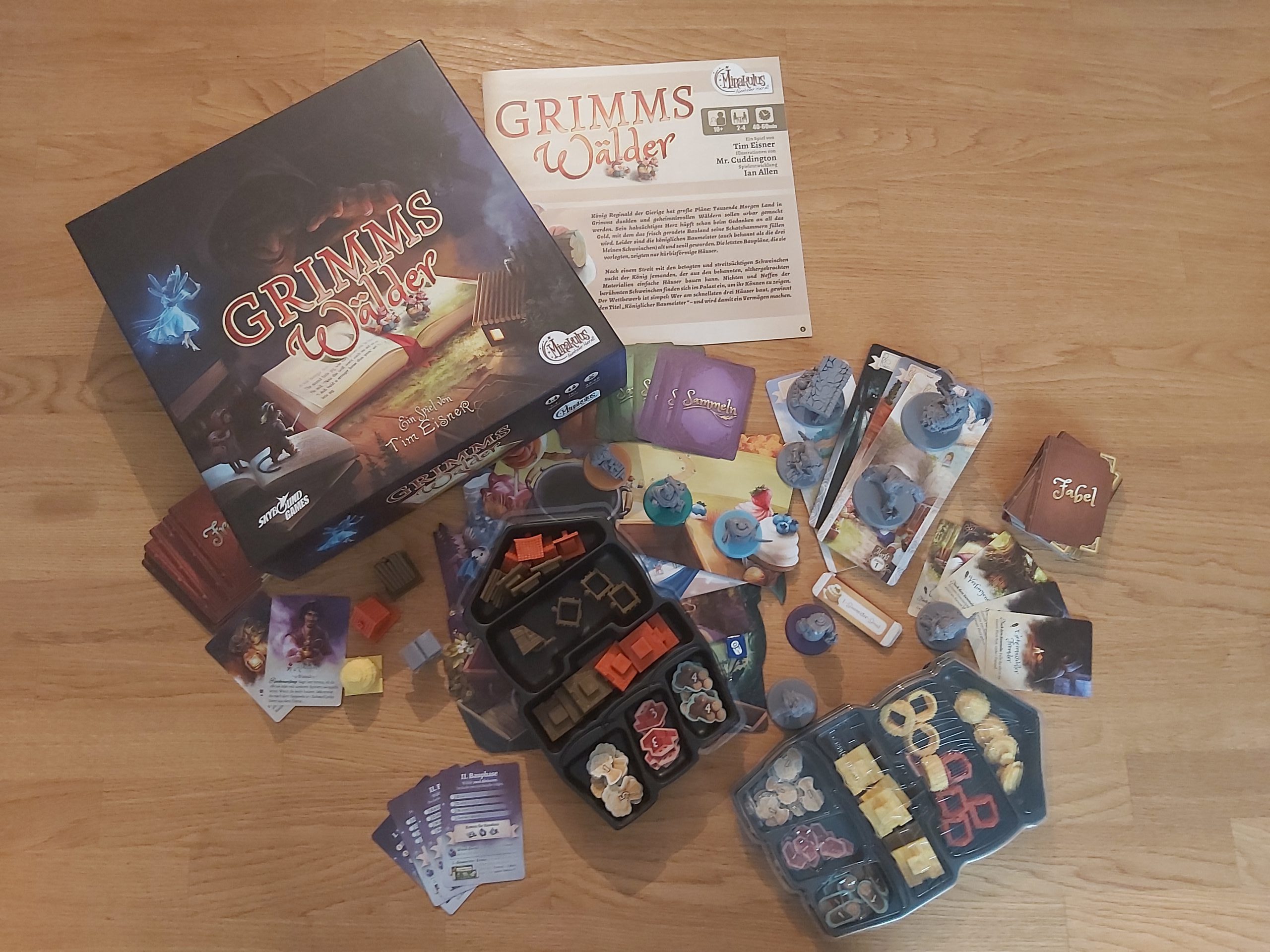 Zu sehen ist das Spiel Grimms Wälder mit dem gesamten Spielmaterial.