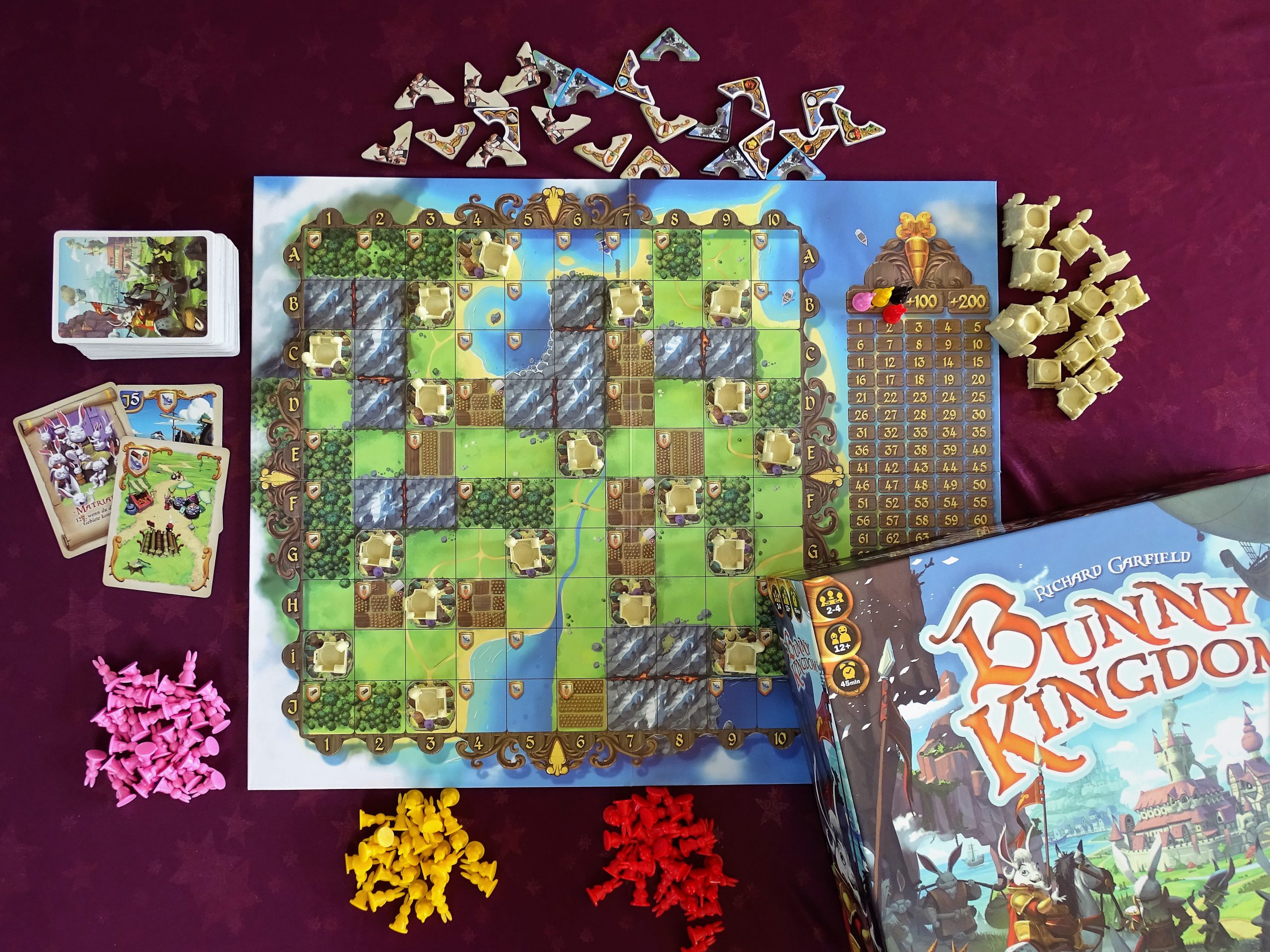 Blick von oben auf Spielplan, Material und den Schriftzug auf der Schachtel