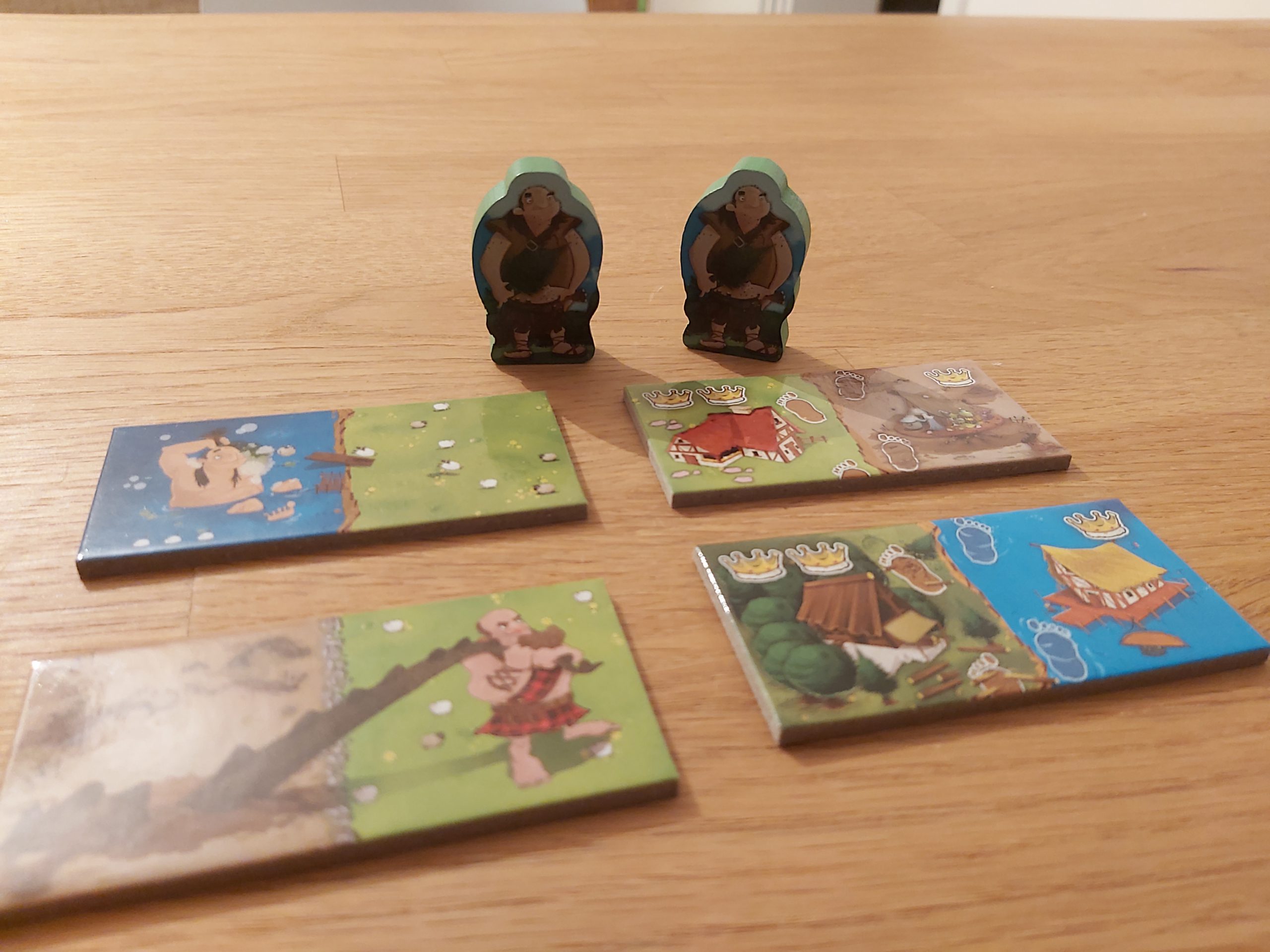 Zu sehen sind die Giganten und Plättchen, mit denen sie ins Spiel kommen.