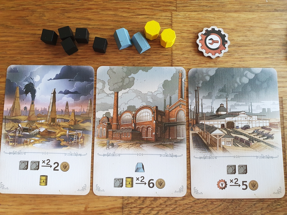 Drei Produktionskarten in fortgeschrittener Partie, dazu Rohstoffe