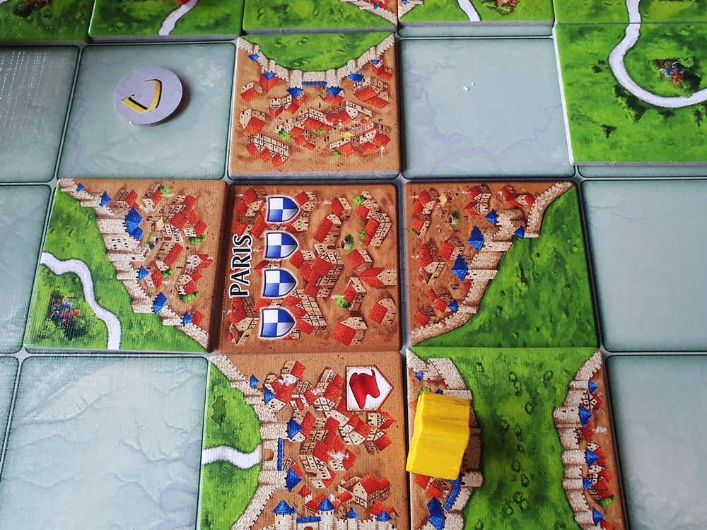 Die Stadt Paris auf dem Spielplan, herum bereits ausgelegte Plättchen