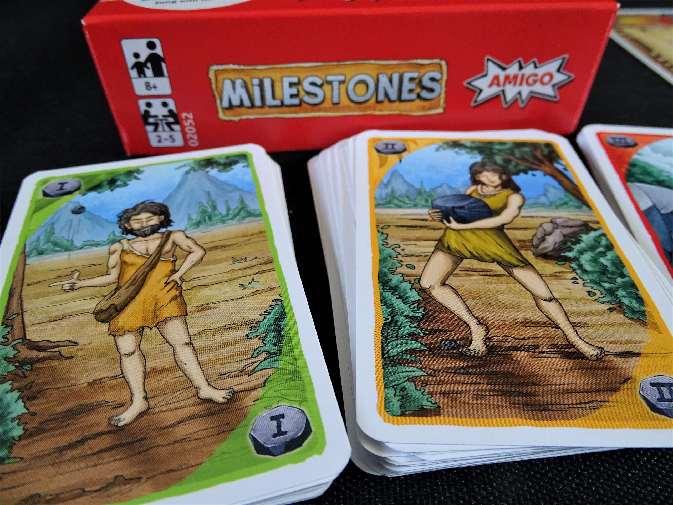 Die Rückseiten der Auftragskarten zeigen Szenen des prähistorischen Lebens