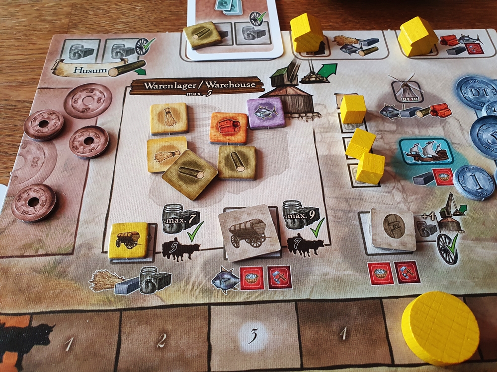 Spielertableau, darauf Ressourcenmarker und weiteres Spielmaterial