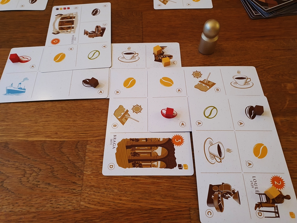 Auslage eines Spielenden gegen Ende der Partie: acht Karten überlappen sich, darauf Ressourcenmarker