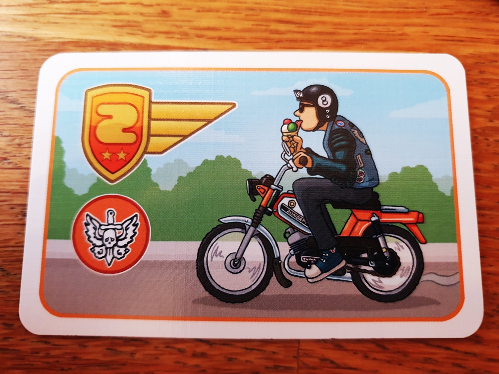 Eine Karte für Orange. Der abgebildete Mopedfahrer isst dabei ein Eis.