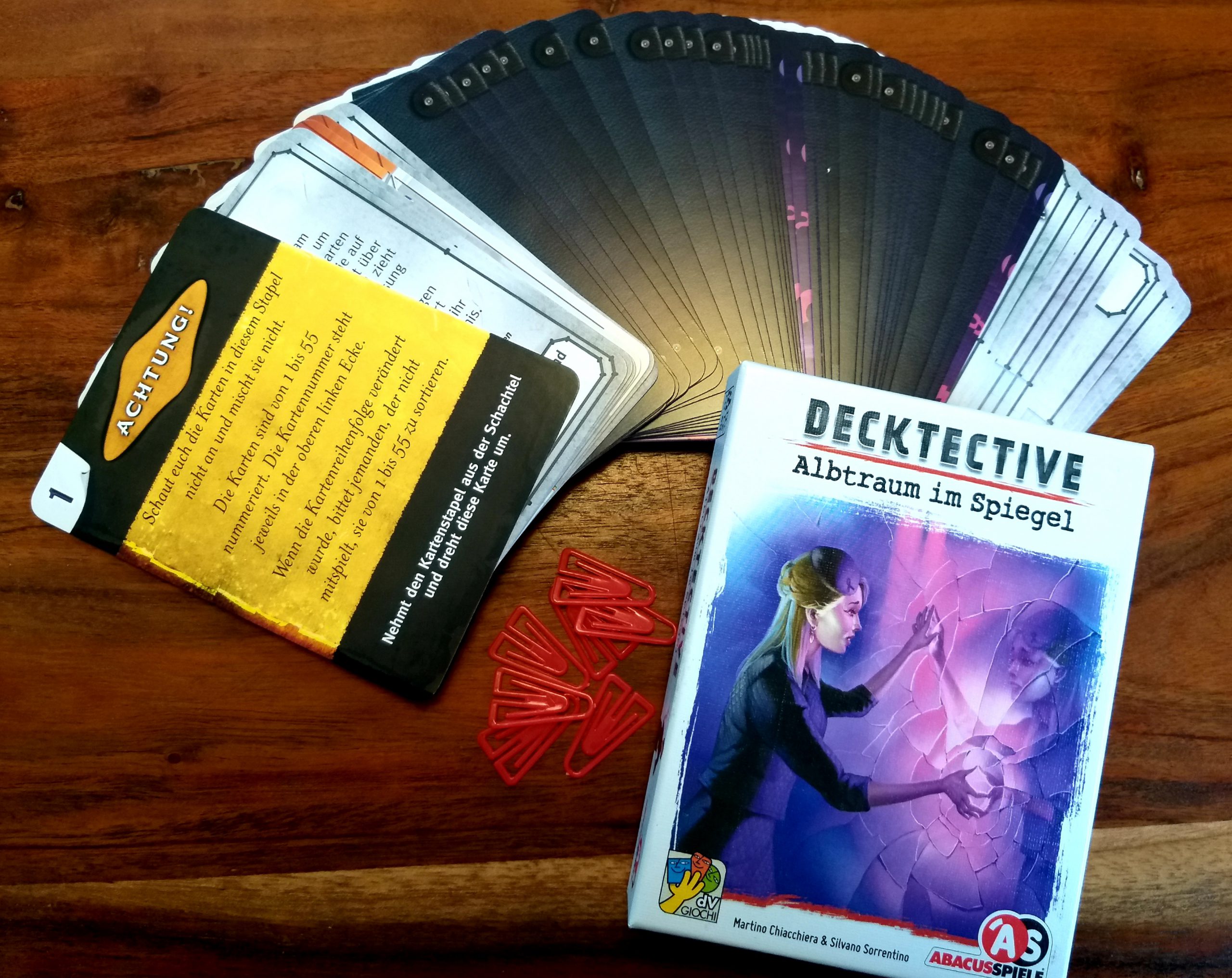 Das Spielmaterial von Albtraum im Spiegel besteht ausschließlich aus Karten, kleinen Kunststoff-Klammern und der Schachtel
