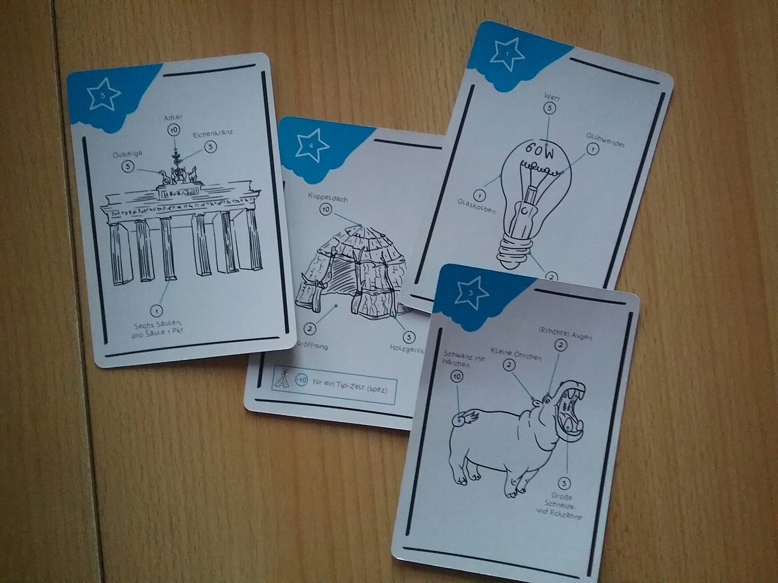 Einige Karten liegen mit der Bildseite nach oben auf dem Tisch. 