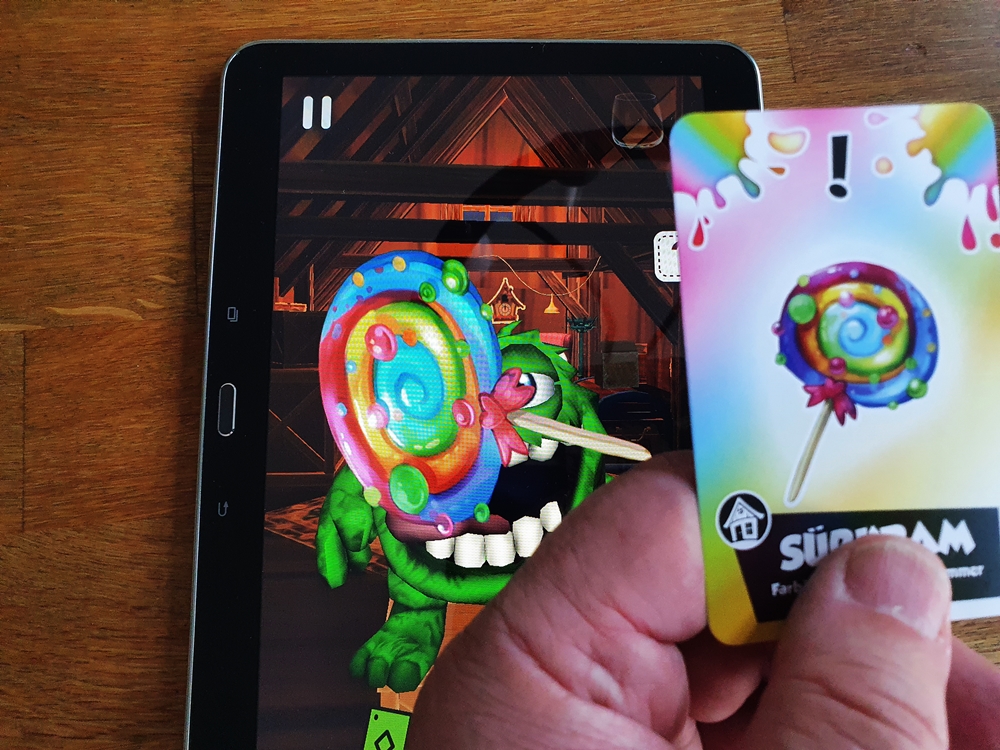 Karte mit Lolly über der Kamera des Tablets, man sieht, dass der Lolly zum Monster wandert.