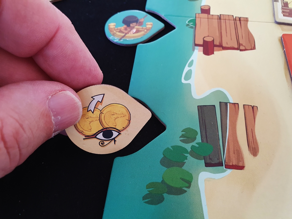 Ein Spielender deckt ein Pirogenplättchen auf