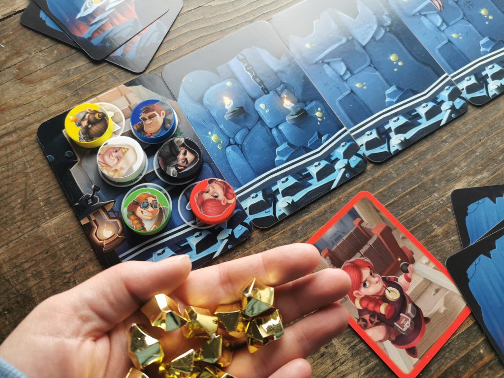 Rundenende: die Spielsteine haben den Höhlenausgang erreicht. Eine Hand zeigt die Beute an Nuggets.