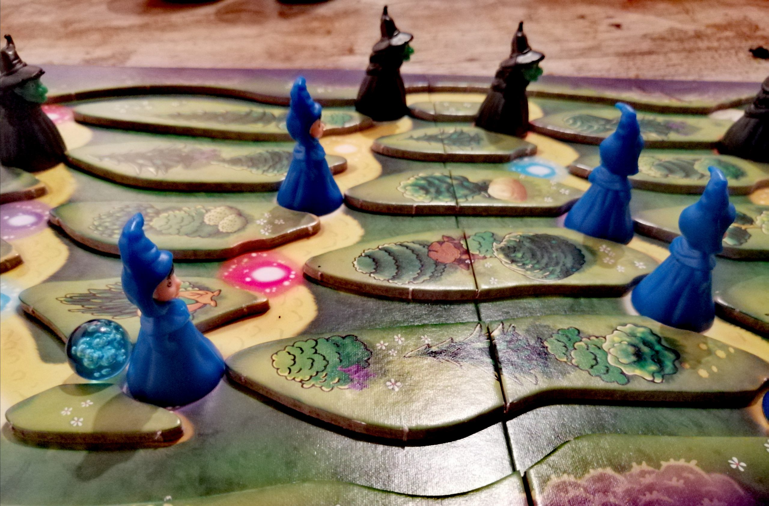 Spielbeispiel. Die blaue Murmel hat bei einem Zauberer Halt gemacht. Diese Figur darf nun zum nächsten blauen Punkt wandern. 