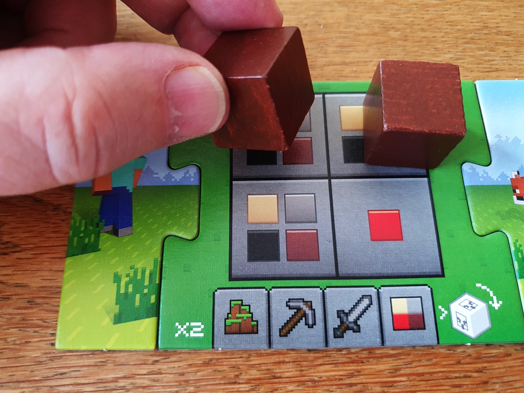 Ein Ressourcenwürfel wird auf ein Spielertableau gelegt