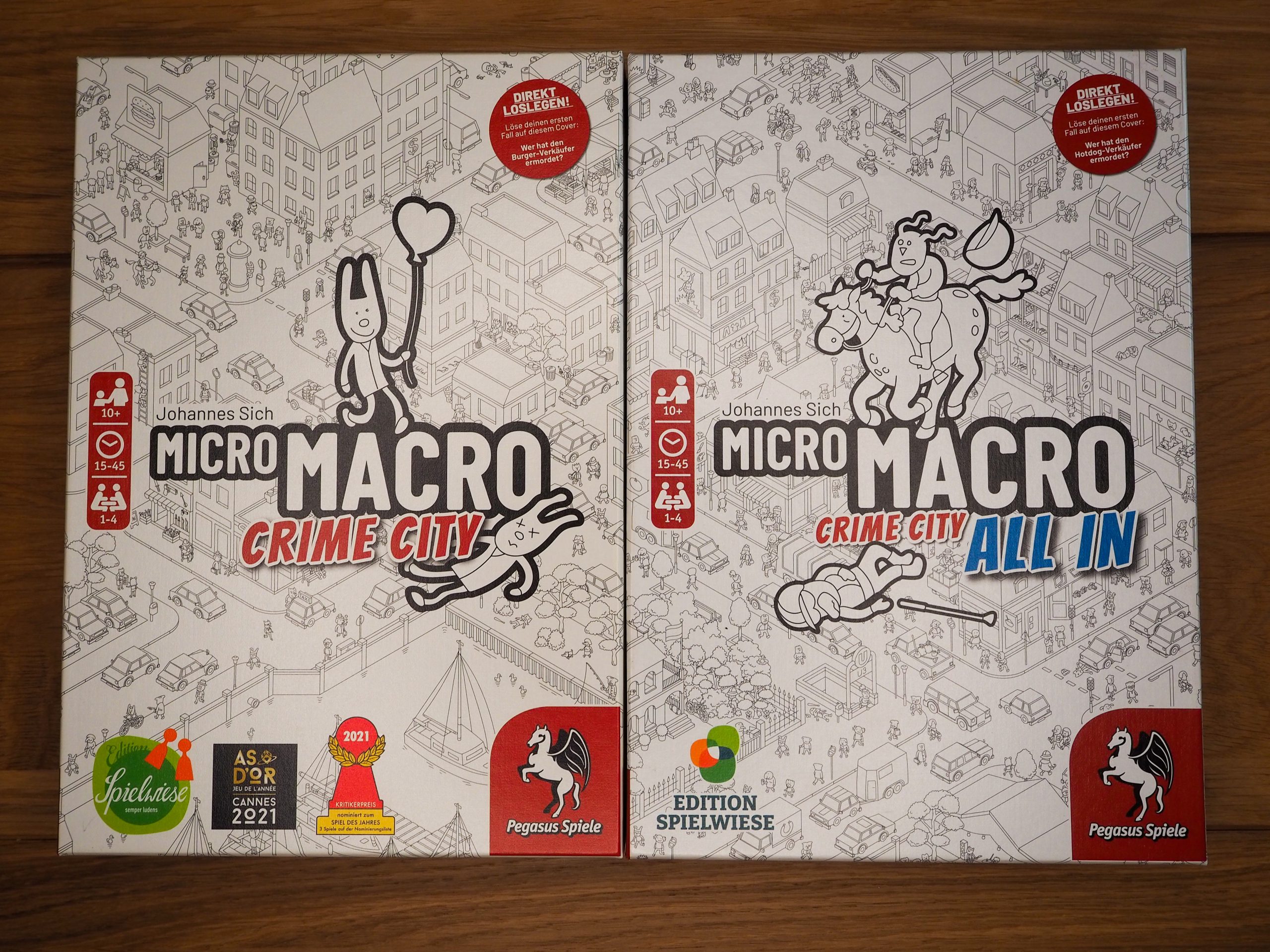 Zwei schwarz-weiß gehaltene Spielschachteln liegen direkt nebeneinander. 