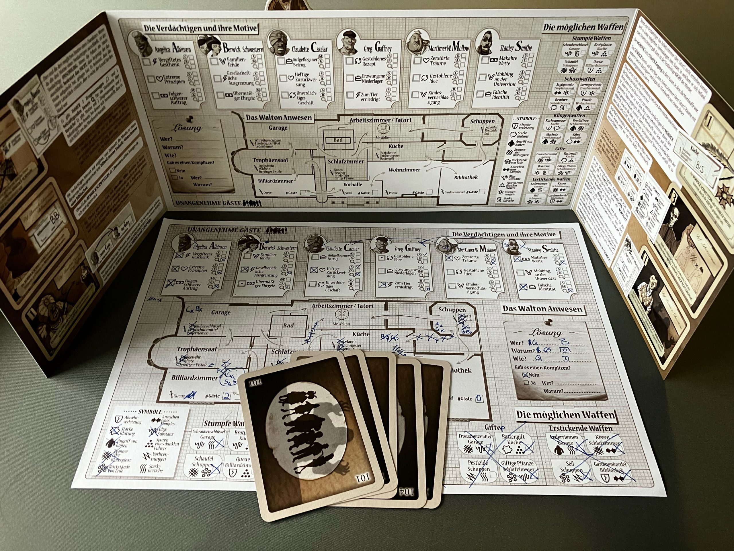 Sichtschirm mit Skizze des Anwesens sowie Notizen im Informationsblock. Karten liegen davor.