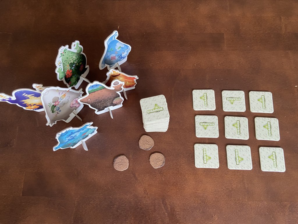 Aufbau 9 Plättchen verdeckt, der Rest als Stapel und die Gigamon Aufsteller