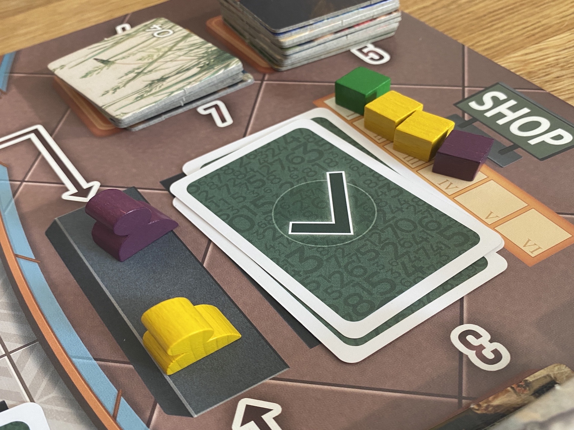 Die Spielfiguren warten im Shop darauf Plättchen zu bekommen