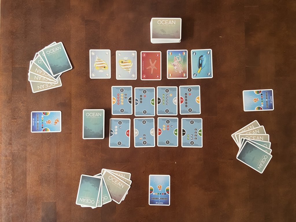Riffkarten und Faunakarten sind auf dem Tisch ausgelegt, sowie die Startkarten und Handkarten für 3 Spielende