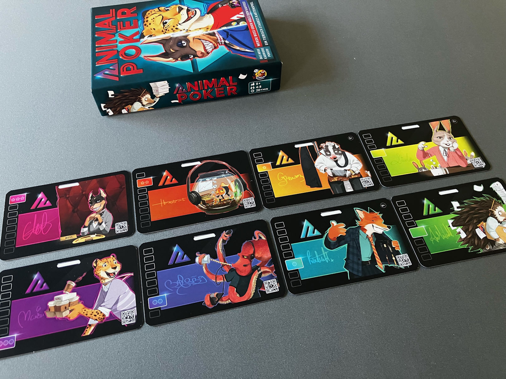 Die 8 Rollenkarten liegen nebeneinander angeordnet - die Spielschachtel darüber