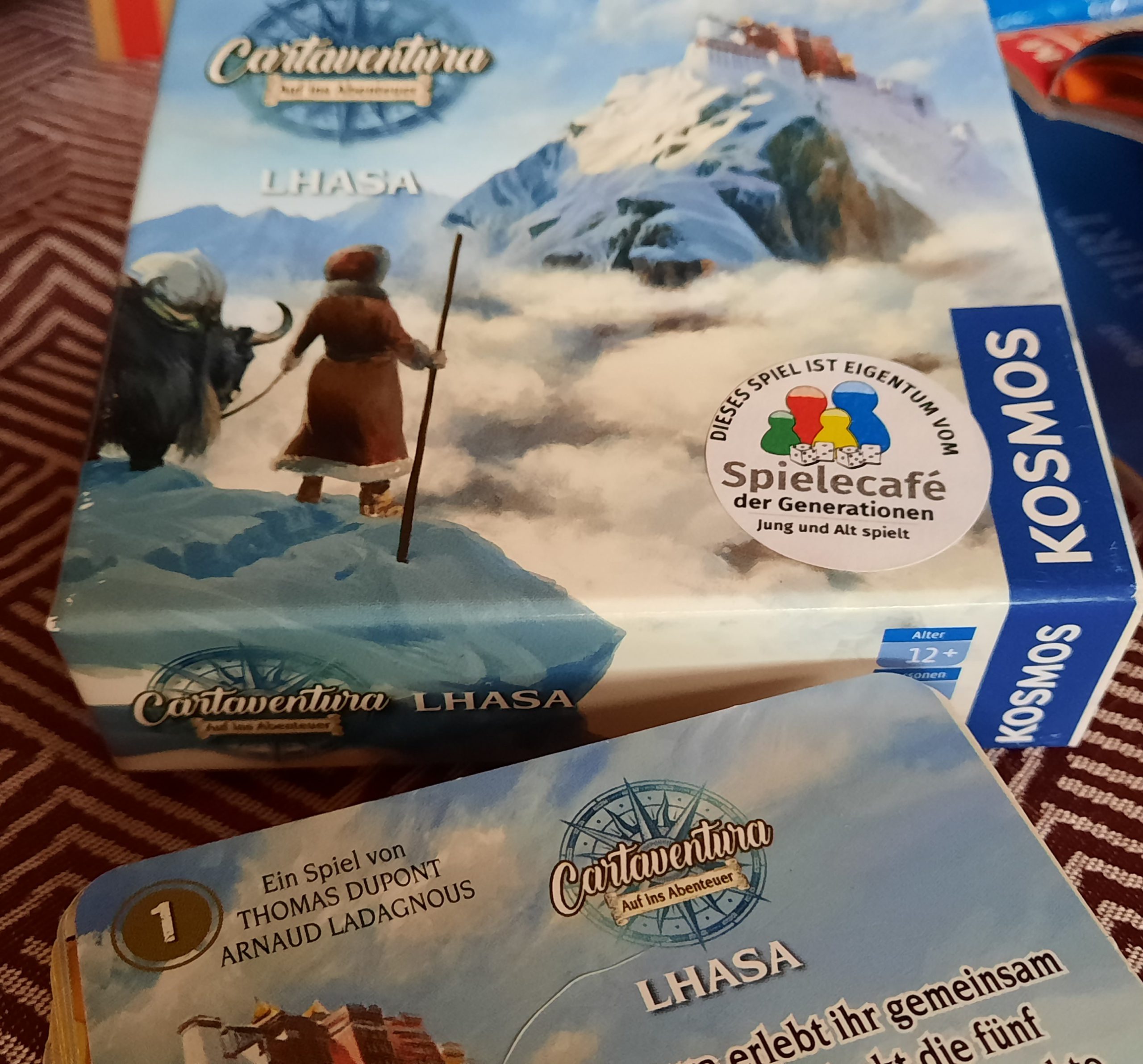 Man sieht die Spielverpackung und einen Kartenstapel.