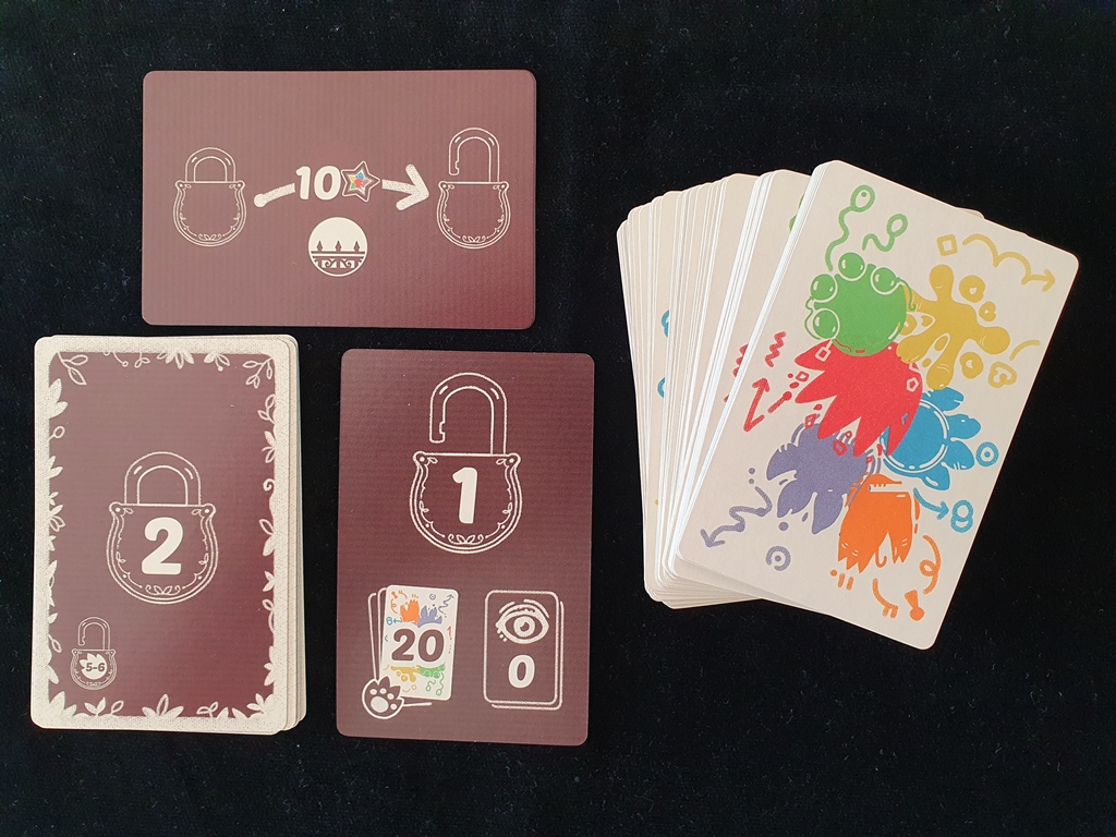 Der Stapel an Gegenstandskarten, die Karte für die mittlere Schwierigkeitsstufe und die erste Karte zur Erfahrungsstufe