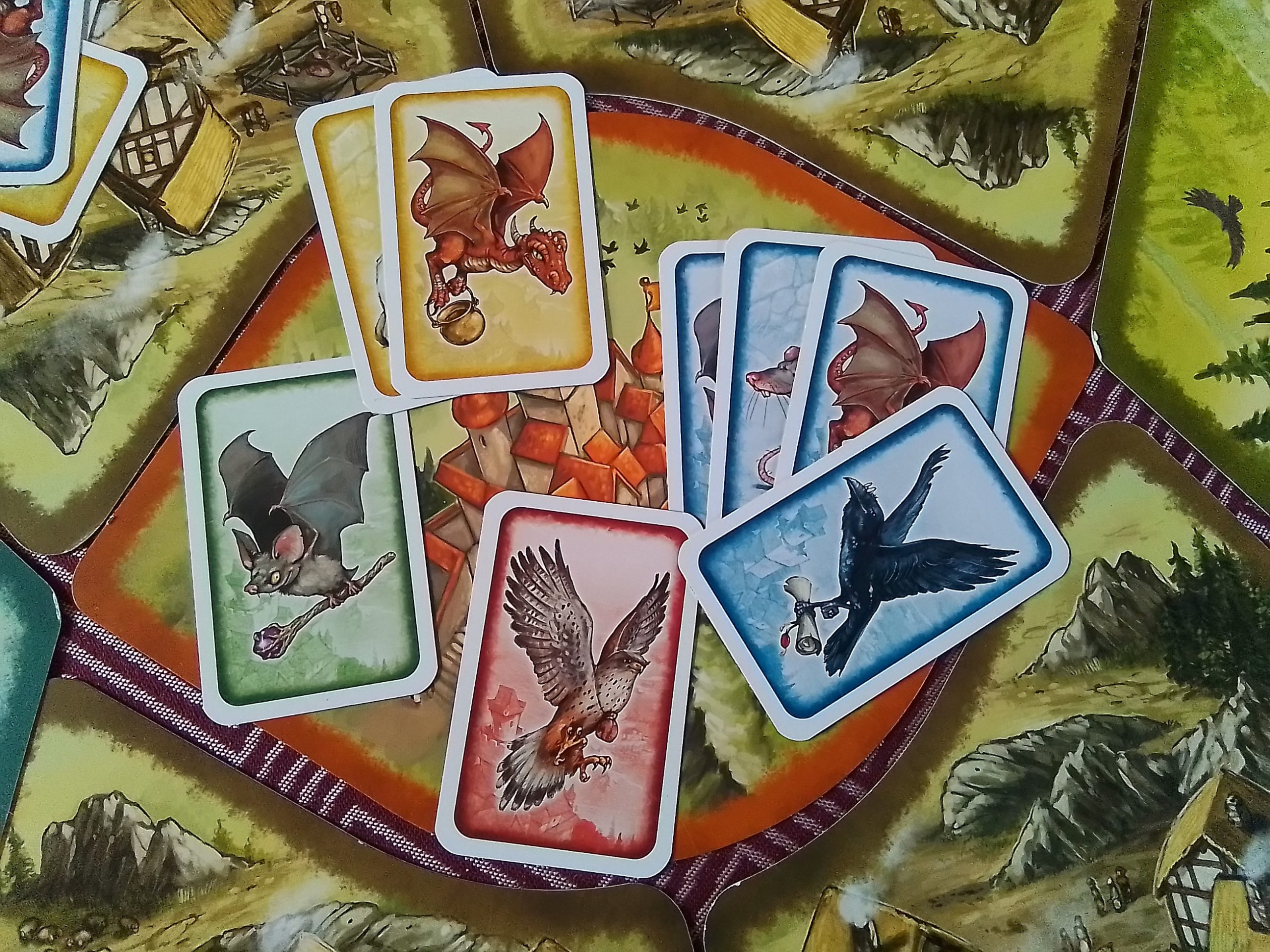 Auf der Landschaftskarte "Burg" liegen 4 blaue, 2 gelbe, 1 rote und 1 grüne Karte.