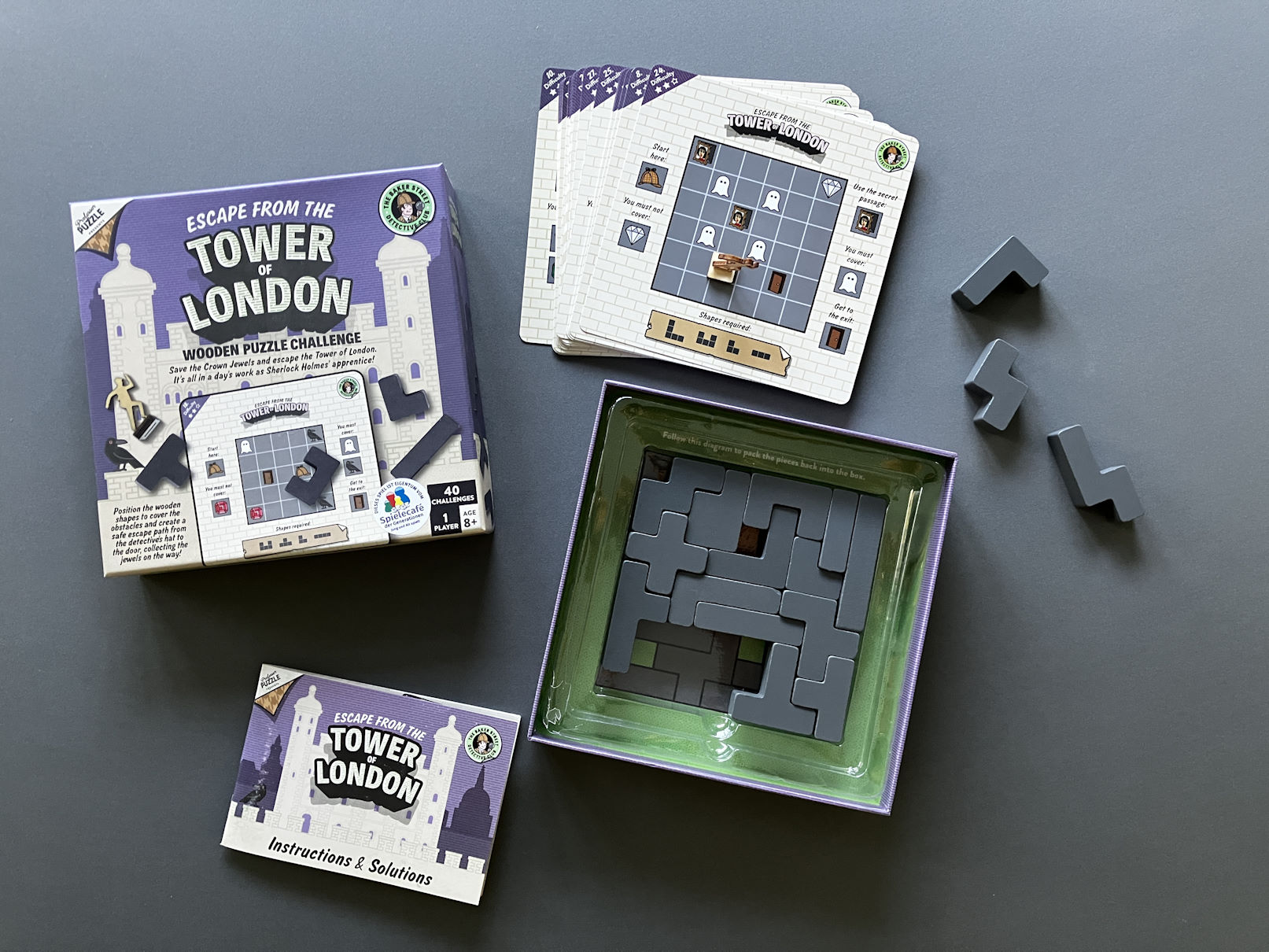 Die Komponenten des Puzzelspiels liegen auf dem Tisch, verschiedene Aufgabenblätter gilt es zu erfüllen