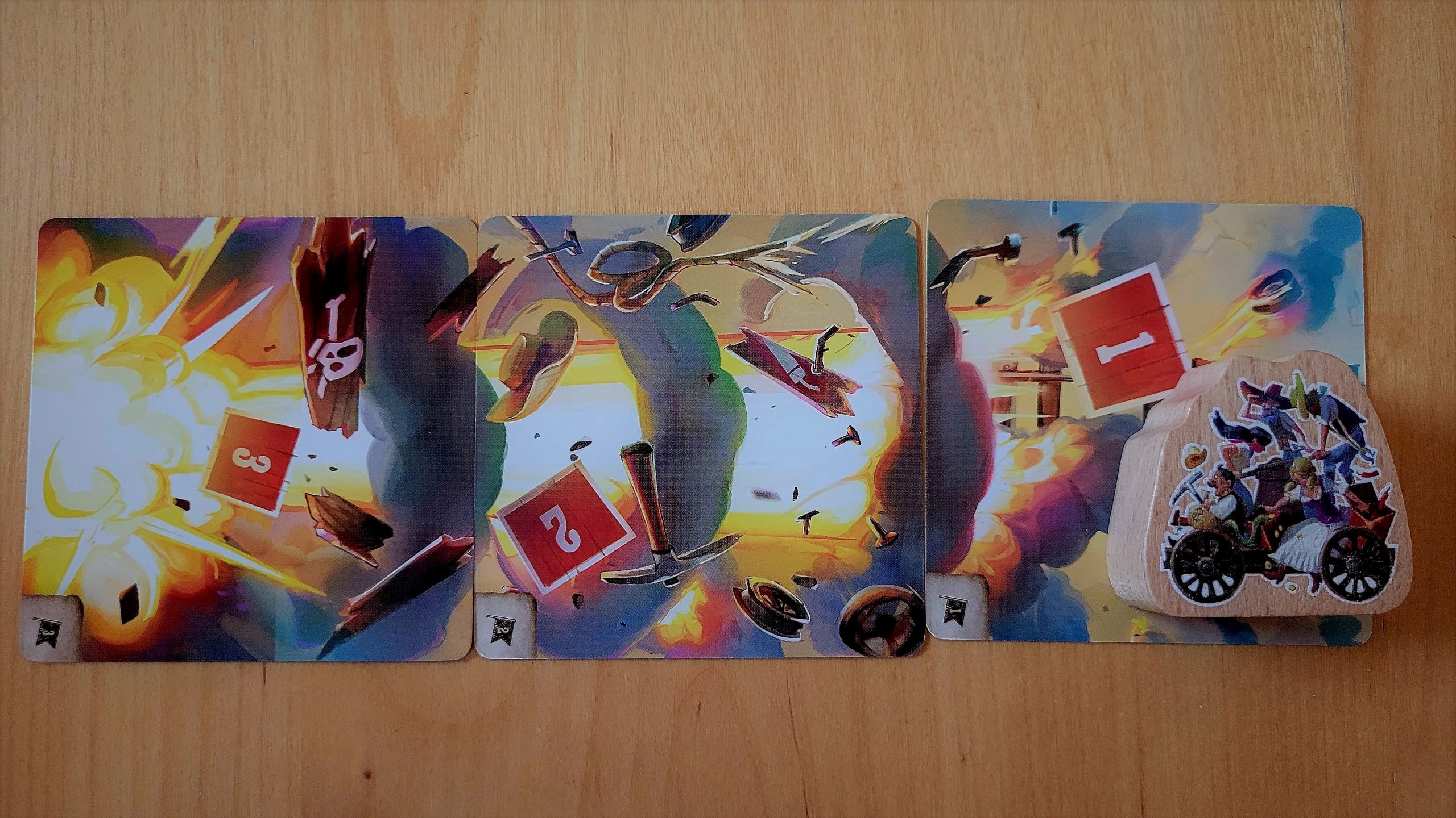 Drei Explosionskarten und die Spielfigur Draisine