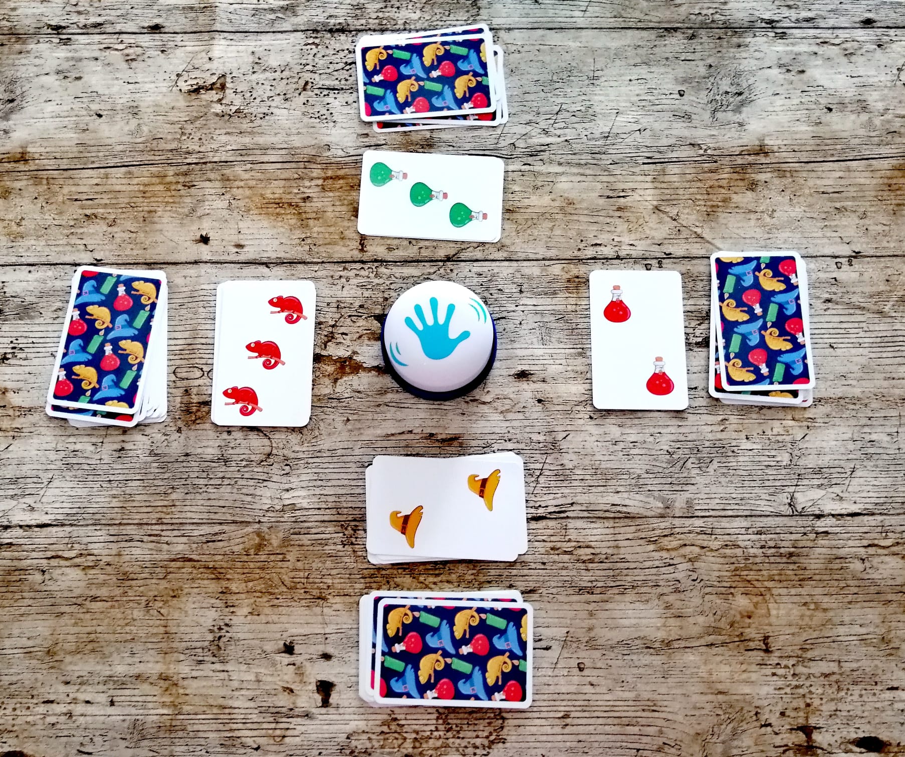 Alle haben Karten vor sich. Wer fünf gleiches sieht, darf auf die Glocke drücken.